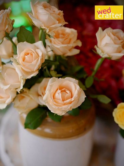 A close-up of delicate peach roses in a traditional ceramic jar, adding a soft, vintage touch to the decor.