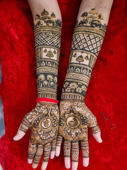A classic bridal design featuring auspicious symbols. The palms have peacocks holding a kalash, and the arms are decorated with temple motifs and lotus flowers.