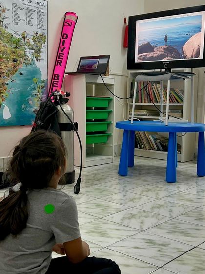A young student captivated by a presentation on marine ecosystems. We aim to inspire the next generation of ocean guardians.