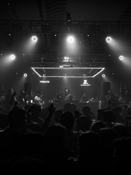 A black and white photo of the crowd in Nashik, with hands raised in unison. A timeless image of a great party.