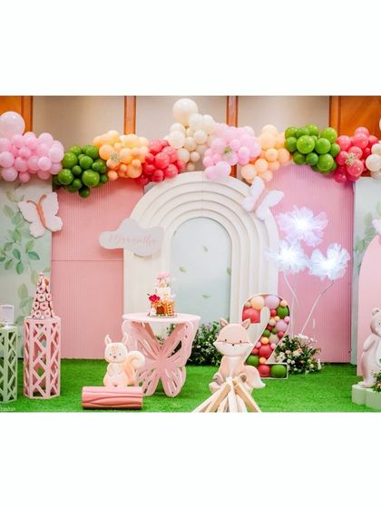 Another perspective of the magical woodland party, showing the intricate details of the backdrops, the butterfly-shaped table, and the glowing flower props that add to the enchantment.