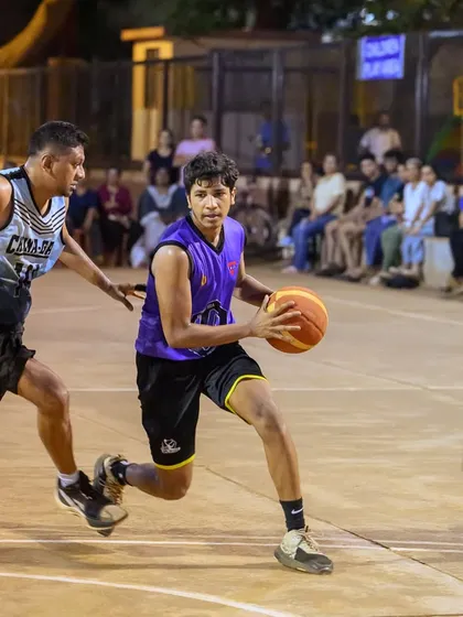 A player from the men's division drives hard to the basket, showcasing his ball-handling skills and determination.