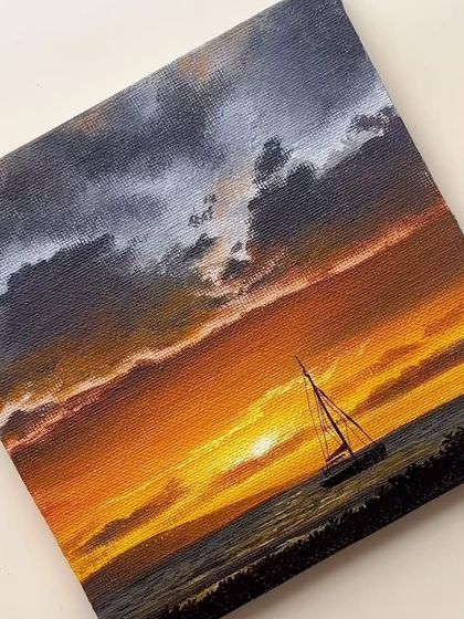 A finished acrylic painting of a sailboat on the sea during a dramatic orange sunset. The dark, moody clouds add a sense of atmosphere to the scene.