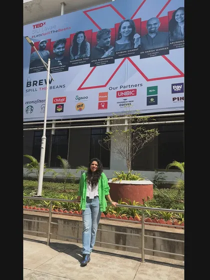Standing in front of the main stage banner at the TEDx event. It was amazing to see my face alongside the other talented speakers and to be a part of such an inspiring day.