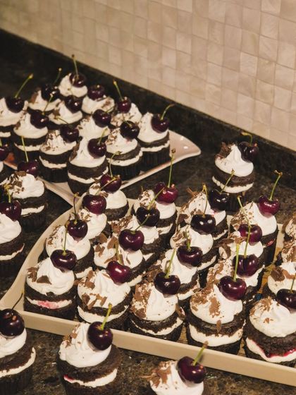 A tray full of Black Forest cupcakes, each one a perfect little tower of chocolate, cream, and cherry. They are ideal for parties and events.