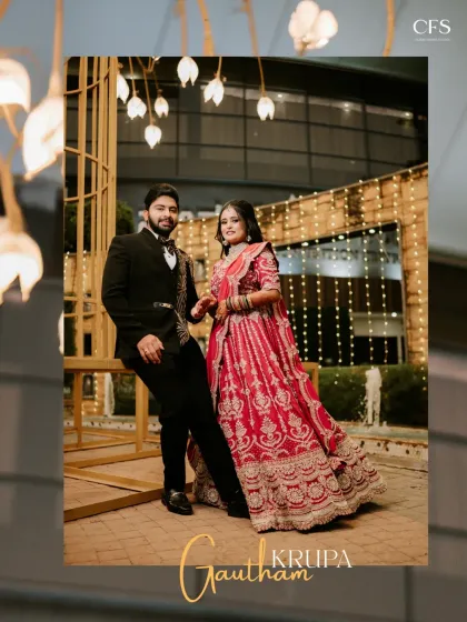 A classic reception portrait of the couple against a beautifully lit backdrop. The bride's stunning red lehenga and the groom's sharp suit create a picture of pure elegance.