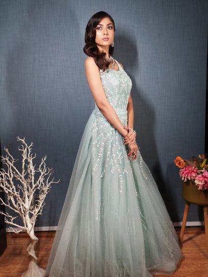 A side profile of a model in the blue gown, highlighting the delicate details on the bodice.