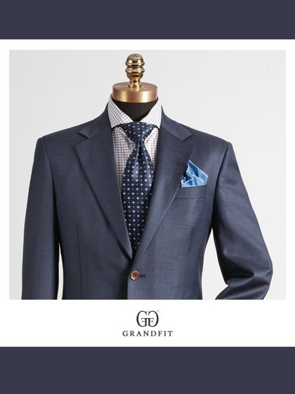 This detailed view highlights the texture of the blue fabric and the expert pairing of a polka-dot tie and a silk pocket square, showcasing our attention to styling.