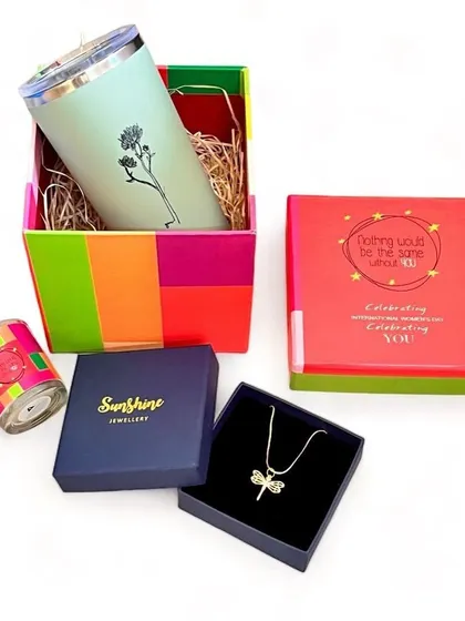 An unboxed view of our Women's Day gift set, showing the dragonfly necklace, sipper, and candle. We can customize these sets to suit your budget.
