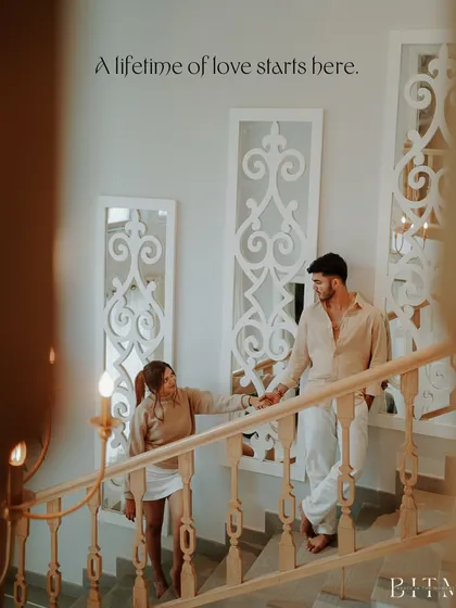 A beautifully composed shot on a staircase in a Goan villa. The text "A lifetime of love starts here" perfectly complements the image of the couple beginning their ascent together.