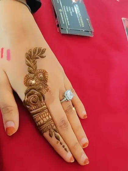 Another example of a single-finger design, this one featuring a rose and leafy vine.
