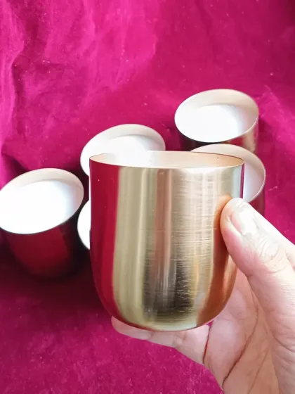 A hand-held view of the brass jar candle, showing its size.