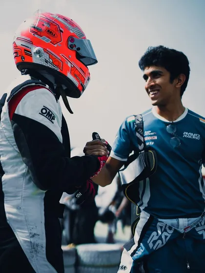 A handshake of sportsmanship between two drivers.