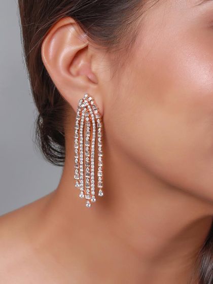 A close-up shot of a model wearing magnificent cascading diamond earrings. This highlights how the jewelry moves and catches the light, adding a touch of glamour and sophistication.