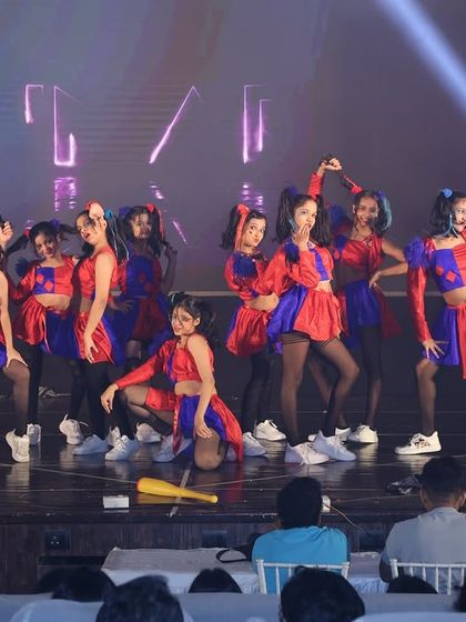 The entire group of performers for the "Harley Quinn's" act, showcasing their synchronized poses and vibrant costumes.