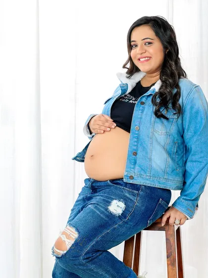 A solo portrait that's cool, confident, and modern. A denim jacket and ripped jeans are a great way to show off your personal style during your maternity shoot.
