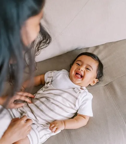 The purest giggle. This candid shot of a baby laughing while playing with his mom on the couch is what lifestyle sessions are all about.