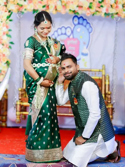 A classic and heartwarming pose where the father-to-be listens to the baby bump, captured in front of the festive baby shower decorations.