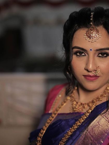 Chinmayi's varpooje look was absolutely captivating. We went for a dramatic smokey eye and a soft pink lip to complement her royal blue and pink Kanjeevaram saree.