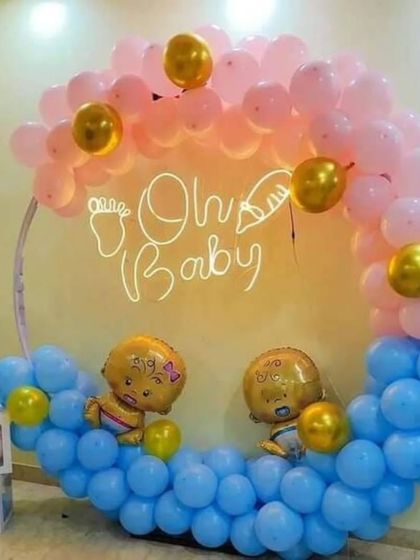 A cute 'Oh Baby' decoration with a half-arch of pink and blue balloons. The transparent 'BABY' boxes and baby-shaped foil balloons complete the theme.