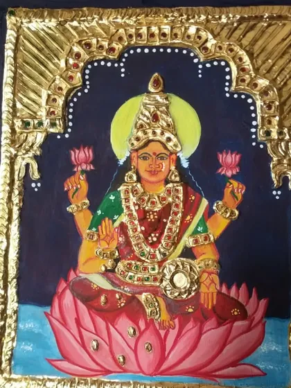 A closer look at the finished Lakshmi Tanjore painting, showcasing the vibrant colors and the texture of the gold foil and stones. Each element is carefully placed to create a piece full of devotion.