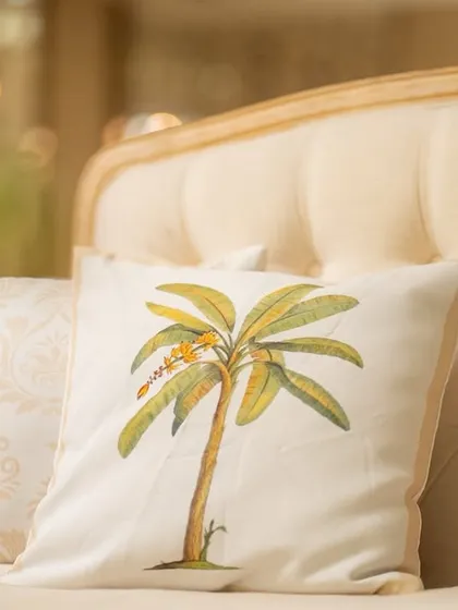 A custom-printed cushion with a banana tree motif, tying into the 'Kel Baradari' wedding theme.