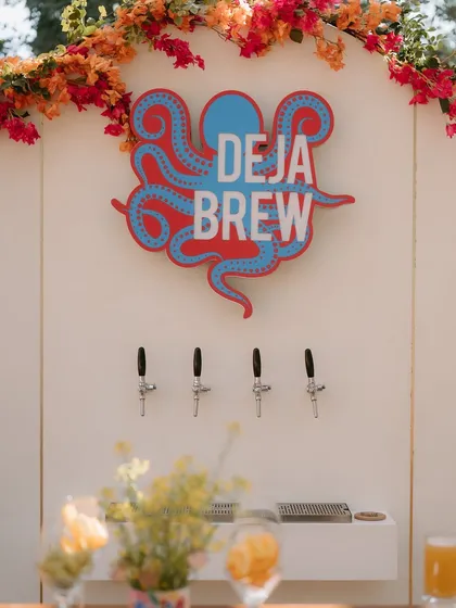 A close-up of the custom "Deja Brew" beer tap sign, featuring a quirky octopus graphic that added to the event's unique personality.