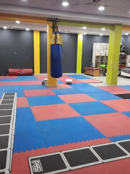 This is our dedicated matted zone. It's a versatile space for martial arts fitness, agility drills using the ladder, and floor exercises. The punching bag is always ready for a high-intensity cardio and striking session.