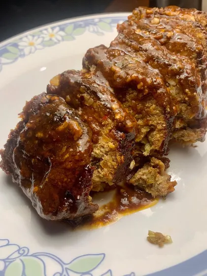 A generous slice of our juicy Pork Meatloaf, covered in a rich, savory glaze. We make it with quality pork mince, the right amount of fat, and fresh herbs from our garden in Coorg.