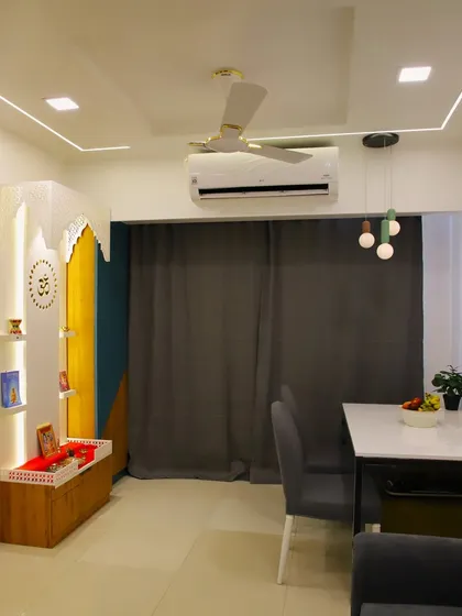 This image shows the dining area in context with the living space and a beautifully designed mandir, showcasing integrated home design.