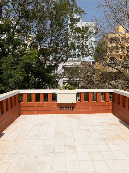 The open terrace with a brick parapet wall offers a private outdoor space with views of the surrounding greenery.
