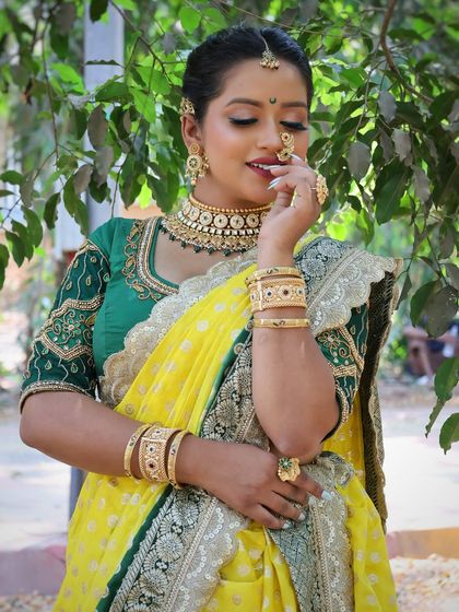 A close-up of the yellow and green Nauvari, focusing on the intricate jewellery and happy expression.