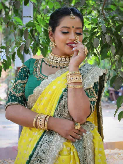A close-up of the yellow and green Nauvari, focusing on the intricate jewellery and happy expression.