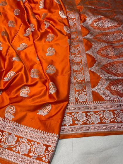 A bright orange Mashru silk saree, a perfect statement piece for any celebration.