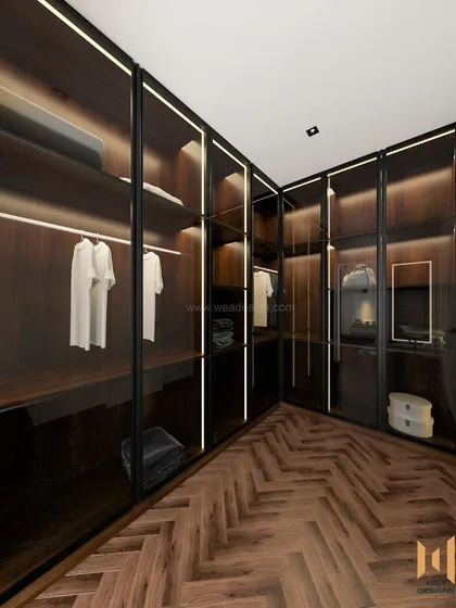 A luxurious walk-in closet with dark wood, glass doors, and integrated profile lighting, creating a high-end boutique feel.
