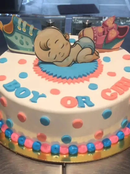 "Boy or Girl?" This adorable gender reveal cake builds the anticipation with its pink and blue polka dot design, topped with edible baby shoes. It's a sweet way to share your big news.
