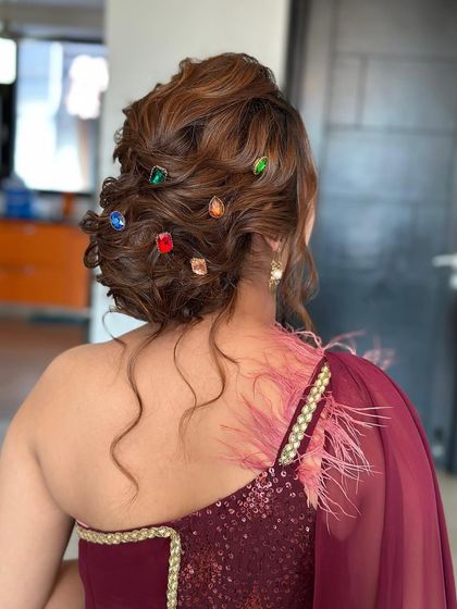 A close-up of a textured bun studded with colorful gems. This is a fun and modern way to accessorize an updo for a sangeet or cocktail party.
