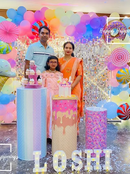 The sweetest family photo from Loshi's Candyland party. The colorful backdrop with a donut, ice cream, and candy-themed balloons created the perfect setting for their family portrait.