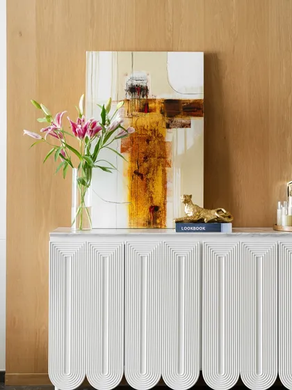 A closer look at the styling on the console table. The abstract art, fresh flowers, and small decorative objects come together to create a curated and personal vignette.