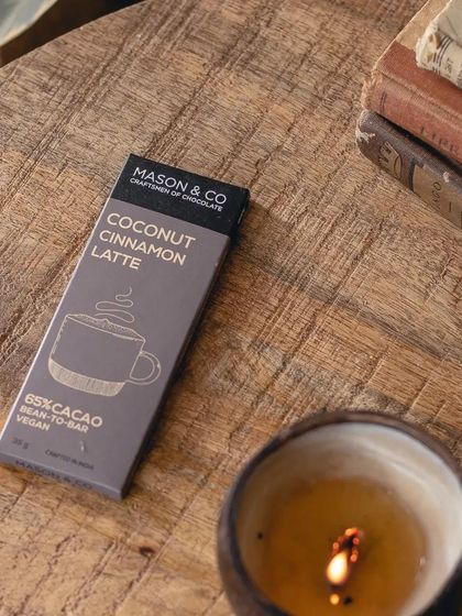 The chocolate bar resting next to a candle and old books. It captures the cozy, warm vibe of our cafe and makes for a perfect gift or personal treat.