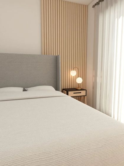 This angle of the bedroom design shows the wingback upholstered headboard and the fluted wooden paneling on the wall, adding texture and warmth.