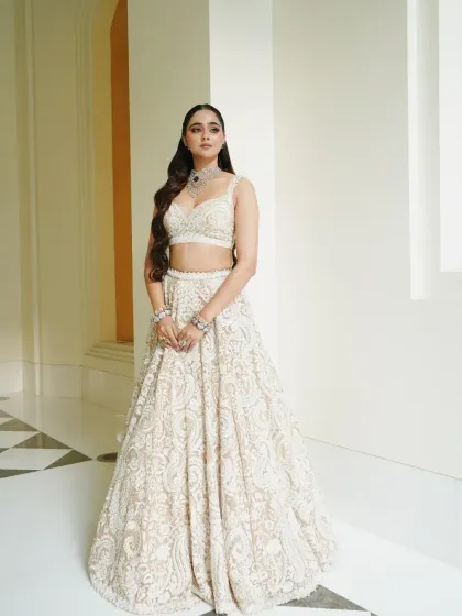 A classic portrait in the white and silver lehenga. The styling is timeless, with a focus on the intricate craftsmanship of the outfit.