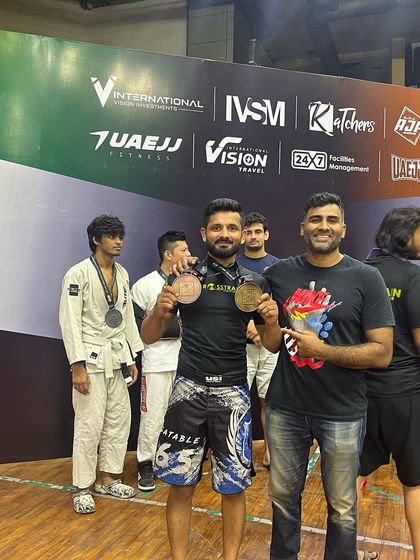 A coach congratulating his student on his medal wins. We are a team that celebrates each other's successes as our own.