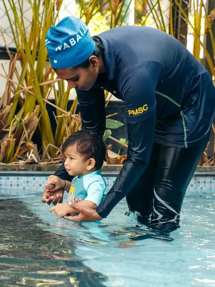It's never too early to start loving the water. In our specialized toddler program, an instructor gently guides one of our youngest members, ensuring their first experience with swimming is positive, safe, and fun.