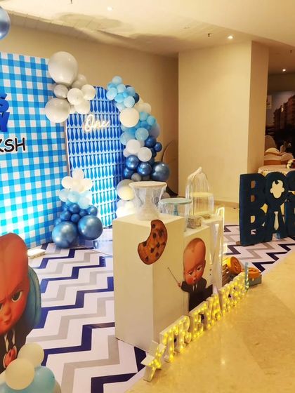 Another angle of the Treyaksh's Boss Baby party, showing the cake table arrangement and large 'BOSS BABY' letters.
