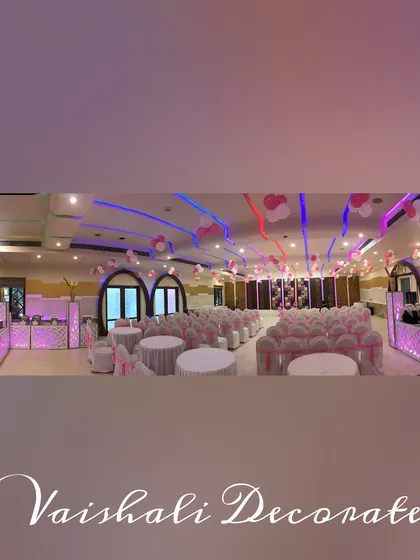A panoramic view of a fully decorated hall. This shows how I coordinate everything from the chair covers and table settings to the ceiling decor and buffet counters to match the pink and white theme.