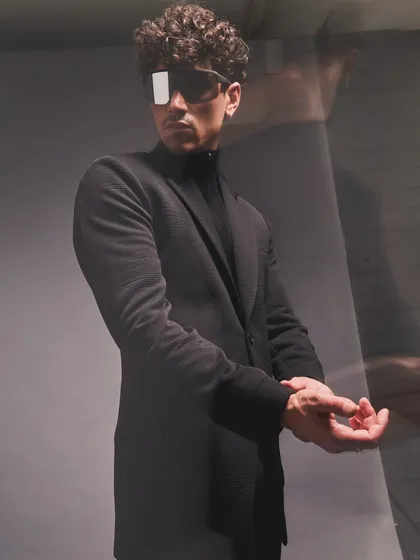 The focus here is on the silhouette and the subtle confidence it projects. An all black ensemble with futuristic eyewear creates a look that is both mysterious and powerful.