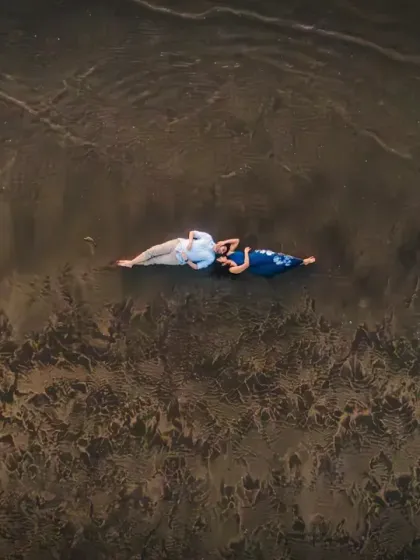 From above, we see a story of quiet connection. Lying on the wet sand as the waves retreat, this aerial view captures a serene, intimate moment, showing that love can be a peaceful escape from the world.