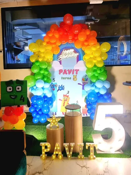 A unique and educational Numberblocks themed 5th birthday party, featuring character cutouts and a rainbow balloon arch.