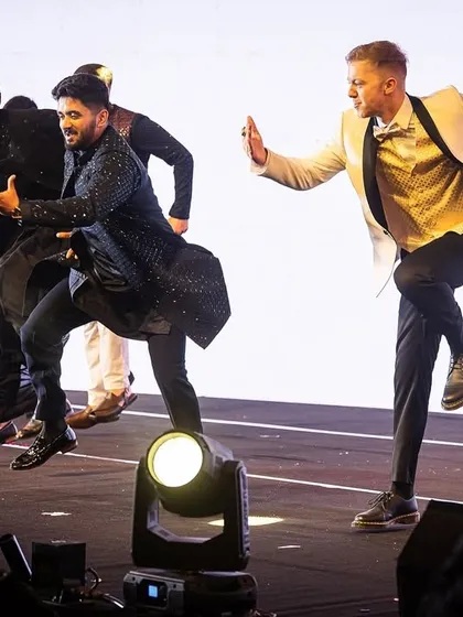 The groomsmen showing off their high-energy, synchronized jumps during their sangeet act.